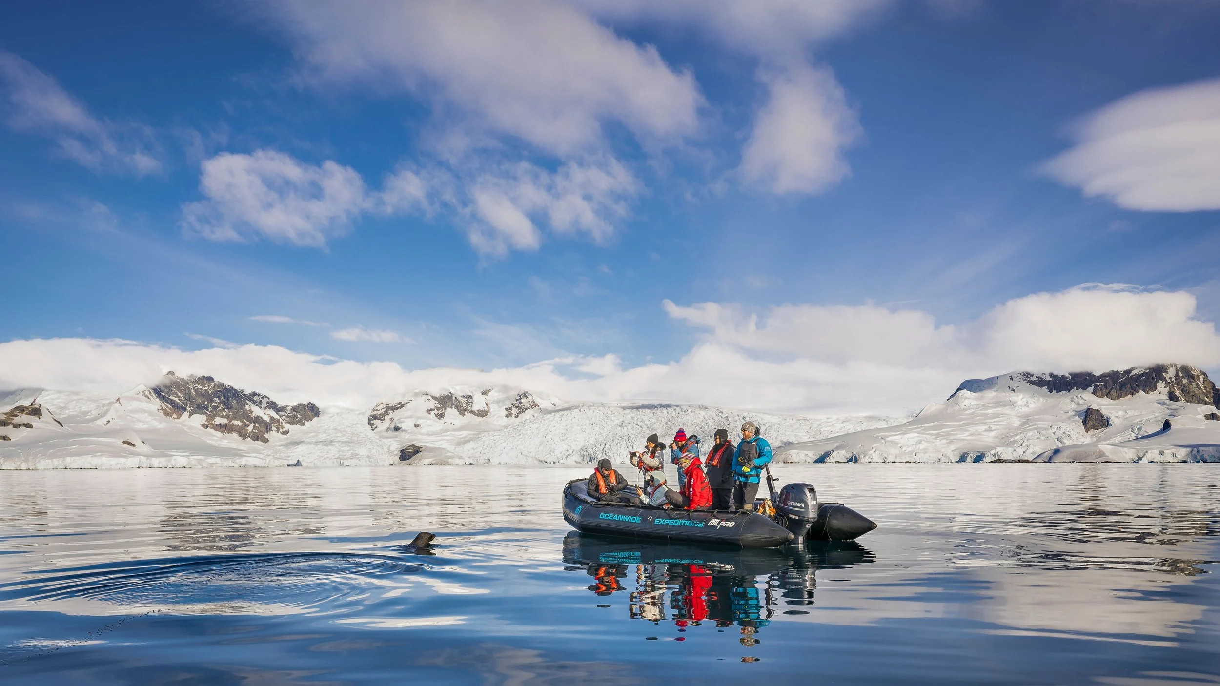 Photographers in a Zodiac among icebergs, Antarctica