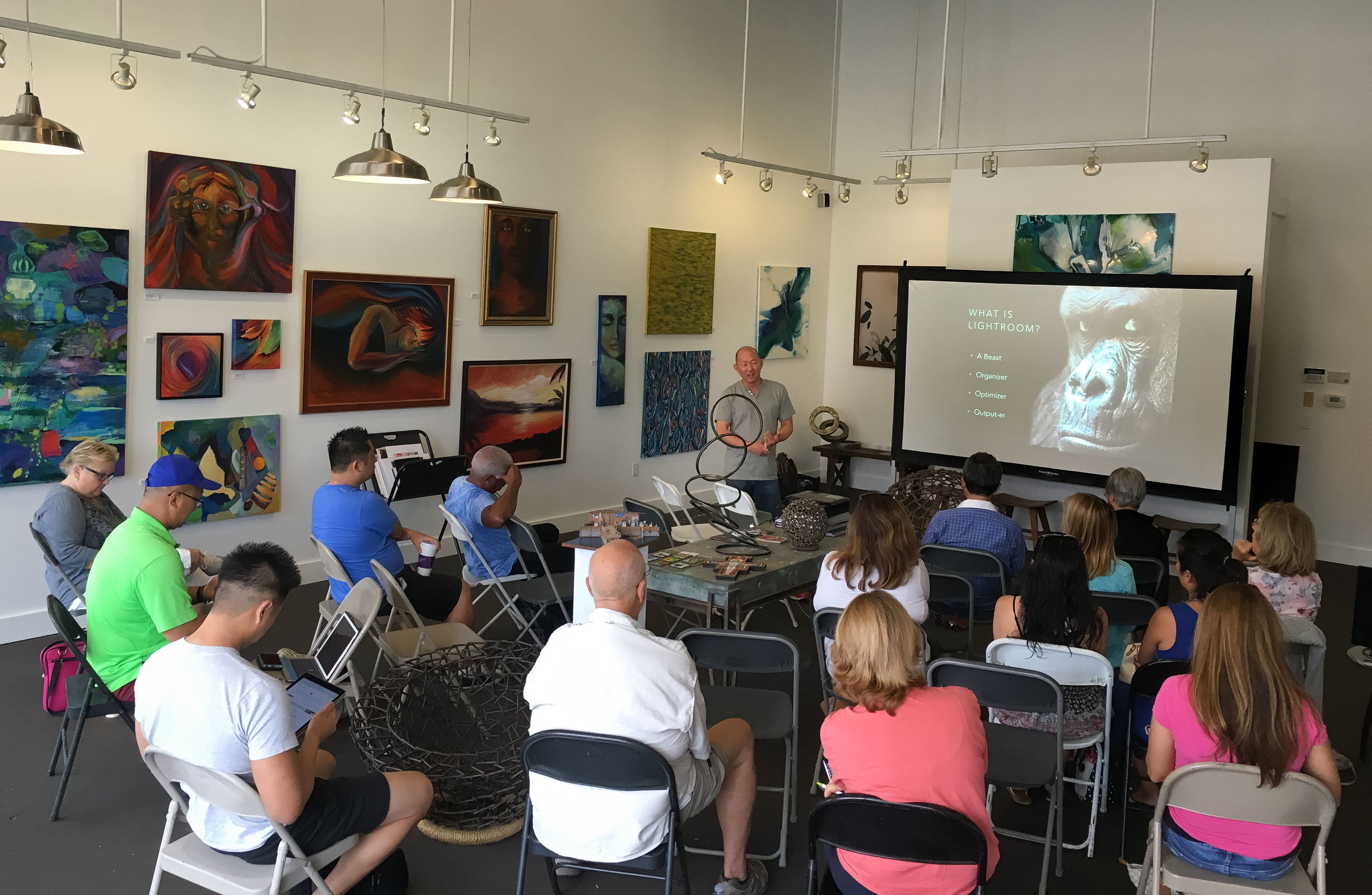 Ken Lee presenting Seeing 101 to an audience in a gallery